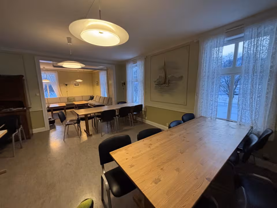 Langt spisebord med åpning til tilstøtende stue